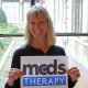 Dr. Melita Irving smiling holding a MCDS Therapy sign